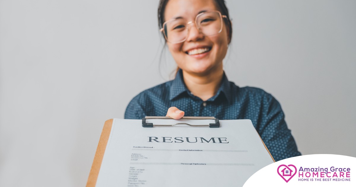 A woman happily hands in a resume, representing a successfully written caregiver resume.