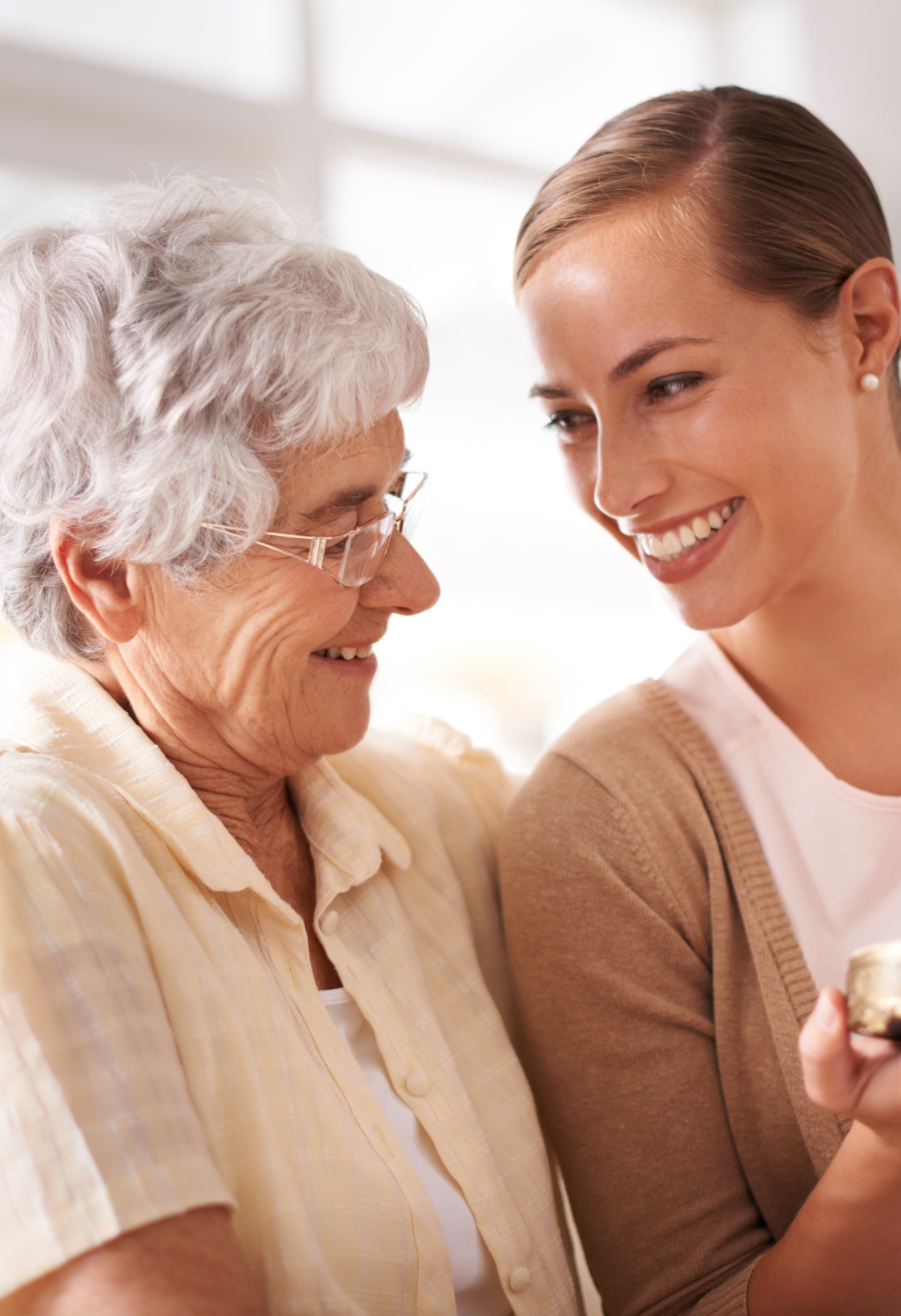 Warm Companionship and Trusted Senior Care in Upper Arlington, Ohio This image shows an elderly woman and her caregiver smiling warmly at each other, representing trust, comfort, and compassionate home care in Upper Arlington, Ohio.