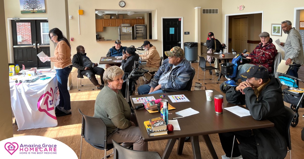 A cheerful group of veterans and seniors playing Trivia Bingo together in a bright community room, smiling alongside an Amazing Grace Homecare event table. Bringing Joy to Lyons Place