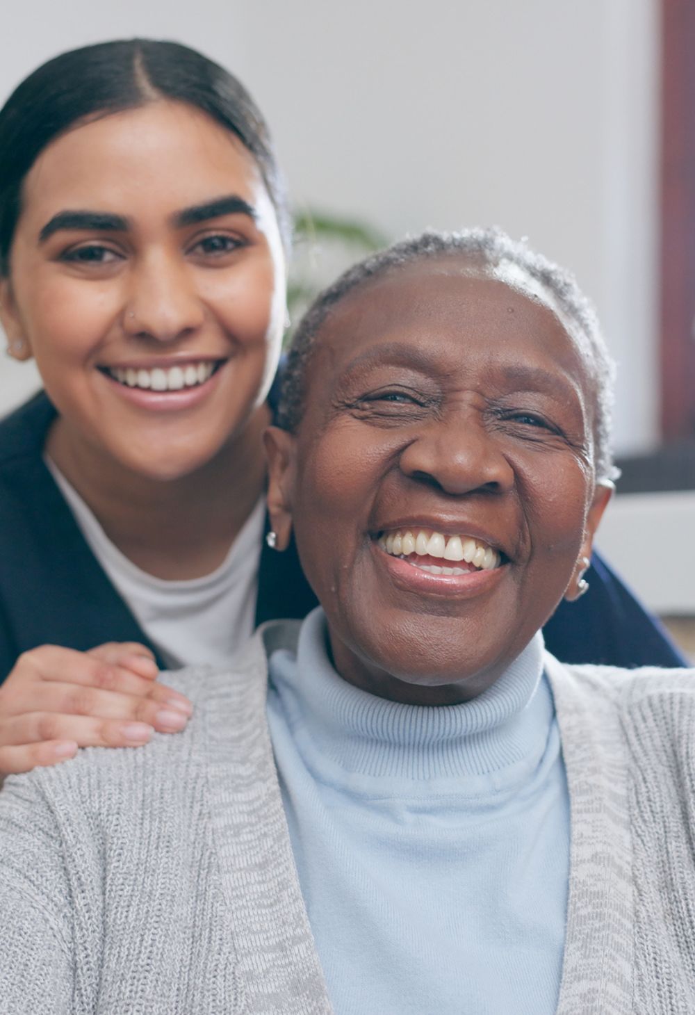 Home Care in Oakwood, OH with a compassionate caregiver smiling alongside a happy senior at home.